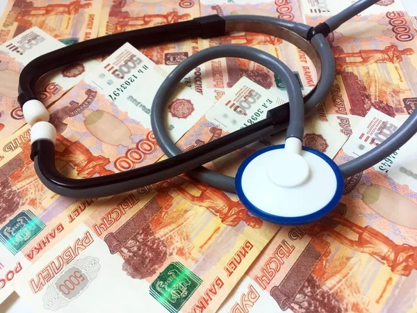 A stethoscope on a background of 5,000 Russian rubles banknotes. Health care. View from above. Close-up.