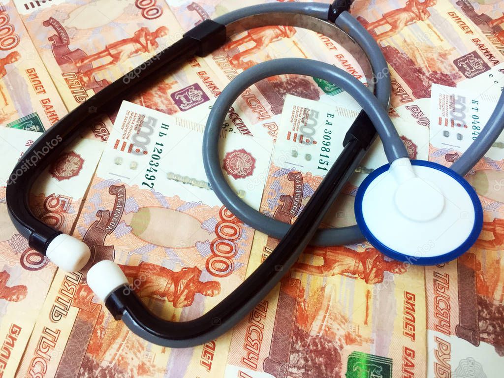 A stethoscope on a background of 5,000 Russian rubles banknotes. Health care. View from above. Close-up.