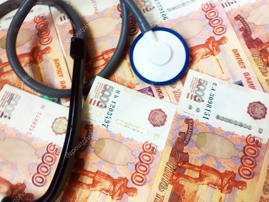 A stethoscope on a background of 5,000 Russian rubles banknotes. Health care. View from above. Close-up.