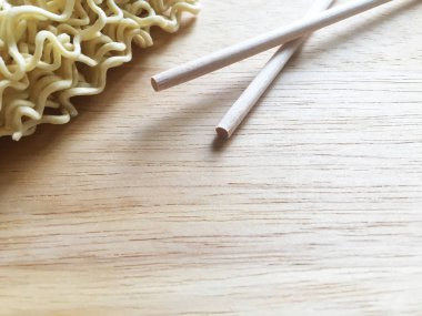 Kuru ince çin anlık erişte ve ahşap bir masa üzerinde ahşap çubuklar. Yakın çekim, üst görünüm.