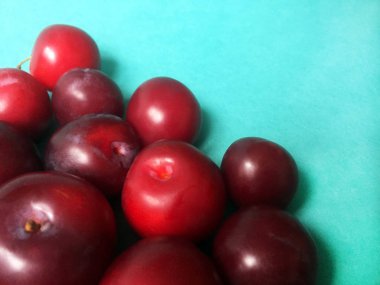 Düz mavi bir arka plan üzerinde olgun sulu erik. Yakın çekim, üst görünüm.