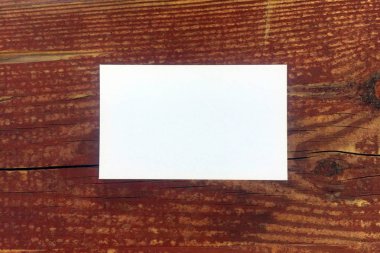 Eski kahverengi ahşap doku yüzeyinde beyaz kartvizit. Arka plan olarak veya iç mekanda kullanılabilir. Kopyalama alanı.