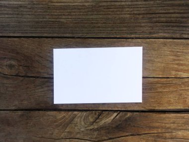 Eski kahverengi ahşap doku yüzeyinde beyaz kartvizit. Arka plan olarak veya iç mekanda kullanılabilir. Kopyalama alanı.