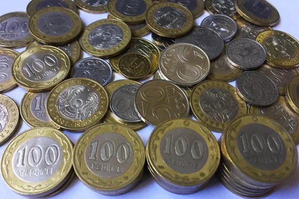 背景としてテーブルの上に1 50と100カザフスタンテンゲの宗派の多くのコイン 100テンゲのコインは 成長量で積み重ねています クローズ アップ — ストック写真