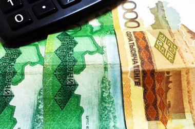 1000, 2000 ve 10000 Kazakistan tenge mezheplerinde banknotlar, bir arka plan olarak masada, 1, 5, 10, 20, 50 ve 100 Kazakistan tenge ve siyah bir hesap makinesi sikke. Close.