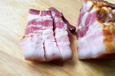Ahşap kesme tahtası üzerinde et katmanları ile dilimlenmiş pastırma. Lezzetli, lezzetli pastırma. Close.