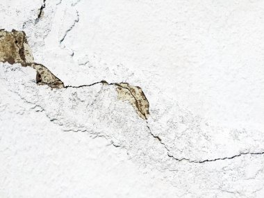Beton duvardaki büyük bir çatlak beyaza boyanmış. Close. Arka plan ve doku. Kopyalama alanı.
