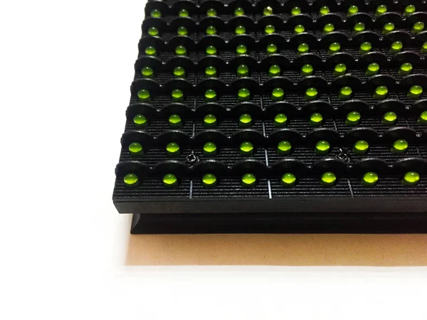 LED module for the manufacture of LED screens and scoreboards on a white background. Green pixels on the LED module. Components for illuminated advertising. Close-up.