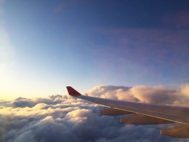 Bir aydınlatıcının penceresinden uçak kanadı. Bulutların üzerinde uçuyor. Close.