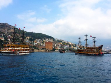 Evler, binalar ve ağaçlar ile güzel derin deniz ve sahil. Güzel doğa ile kıyı boyunca Akdeniz'de bir gemi veya yat seyir.