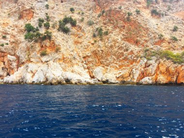 Akdeniz kıyılarında küçük dalgalar ve sarp kayalıkları olan güzel derin deniz. Ağaçları ve mağaraları olan. Kayalık sahil boyunca bir gemi ya da yat ile güzel bir doğa ile deniz yolculuğu..