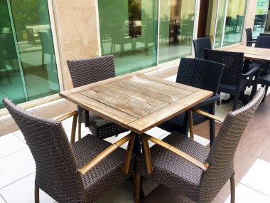 Bir restoran veya otelde bir teras tasarımı kavramı. Büyük vitray pencereler, mermer zeminler, yumuşak yastıklı hasır sandalyeler ve ahşap masalar. Close.