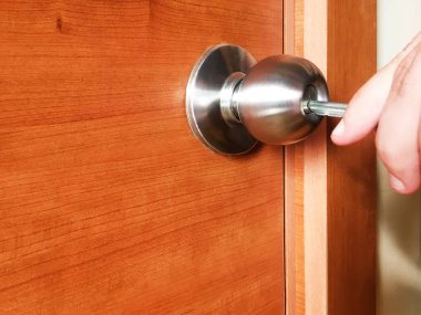 Anahtar kapı kilidine yerleştirilir. Anahtar erkek elinde. Ahşap kapıda metal kilit. Close.