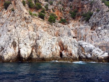 Akdeniz kıyılarında küçük dalgalar ve sarp kayalıkları olan güzel derin deniz. Ağaçları ve mağaraları olan. Kayalık sahil boyunca bir gemi ya da yat ile güzel bir doğa ile deniz yolculuğu..