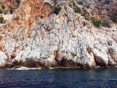 Akdeniz kıyılarında küçük dalgalar ve sarp kayalıkları olan güzel derin deniz. Ağaçları ve mağaraları olan. Kayalık sahil boyunca bir gemi ya da yat ile güzel bir doğa ile deniz yolculuğu..