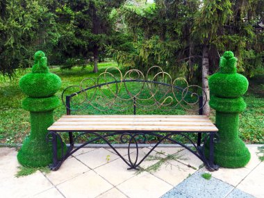 Yanlarda satranç taşlarının taklidi ile park bankı. Parkın tasarımı için ilginç bir kavram. Close.