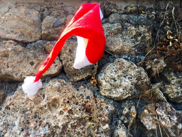 Roter Weihnachtsmann Hut Auf Einer Steinmauer Das Konzept Für Das — Stockfoto