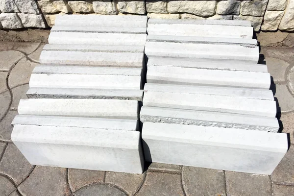 New blanks for concrete curbs for the repair and construction of roads and sidewalks. Close-up.