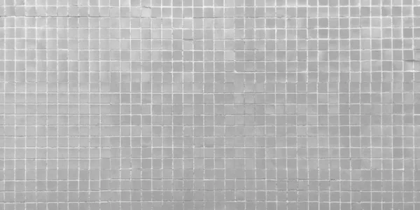 Part of the wall is decorated with a small square mosaic tile in gray. Can be used as background, texture and in the interior.