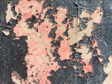 Çatlaklı eski bir beton duvarın parçası. Beton duvarda siyah ve pembe sıva. Yakın çekim, ilginç arka plan ve doku.