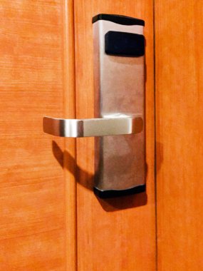 Ahşap kapıda metal saplı bir kilit ve kart okuyucu. Close.