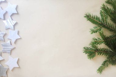 Beyaz ve gümüş yıldız figürleri ve hafif bir arka plan üzerinde küçük iğneler ile yeşil ladin bir dalı. Noel ve Yeni Yıl konsepti. Arka plan ve doku. Close. Kopyalama alanı.