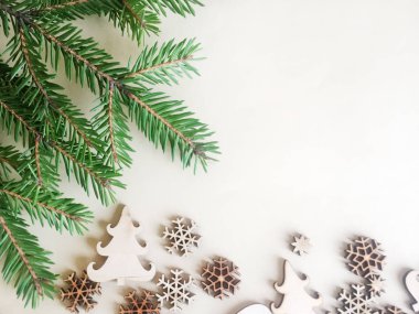 Kar taneleri, Noel ağaçları ve ahşap ve hafif bir arka plan üzerinde ladin yeşil bir dalı oyulmuş evlerin Rakamlar. Noel ve Yeni Yıl konsepti. Close. Kopyalama alanı.