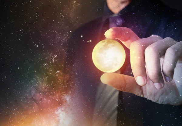 Businessman hold crystal clear ball model with universe galaxy background