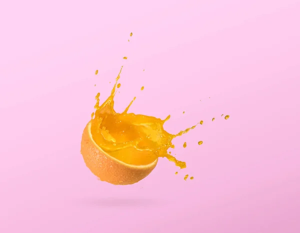 Slice of orange, orange juice splash isolated on plain background