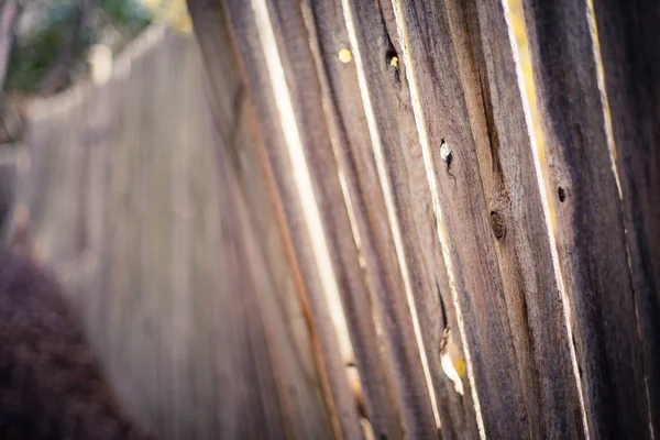Light shining through old crooked fence — Stock Photo, Image