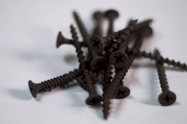 Beyaz bir arka planda siyah bir vida uzanır.