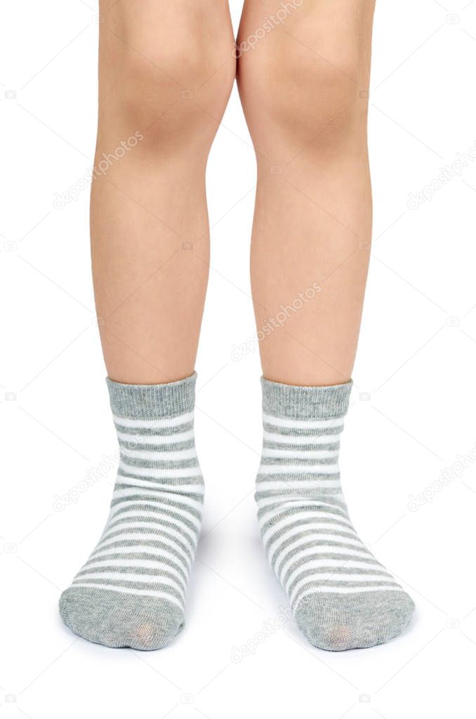 Kid legs in striped socks isolated on white background.