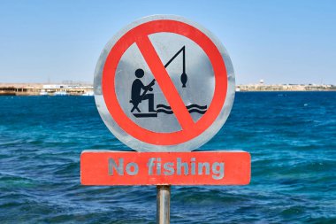 Sign in front of water asking people not fishing. clipart