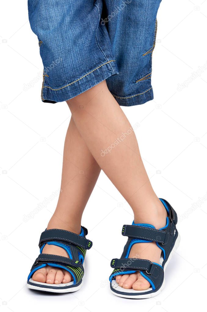 Kids leather sandals on leg isolated on a white background.