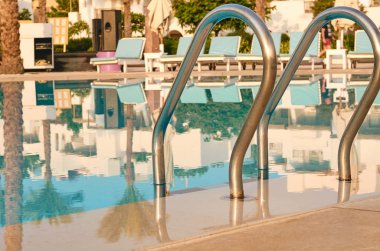 mavi su ve metal bir merdiven Yüzme Havuzu.