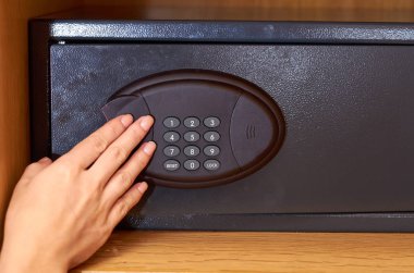 Otel ahşap dolap içinde el ile siyah elektronik kasa kompakt.