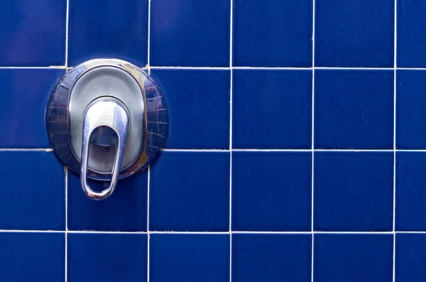 blue square tile in the bathroom with a faucet.