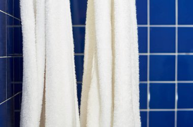 mavi kare kiremit ile beyaz bir havlu banyoda.