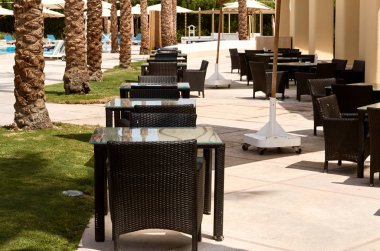 karanlık sandalye ve masa bir kafede açık bir platform üzerinde.