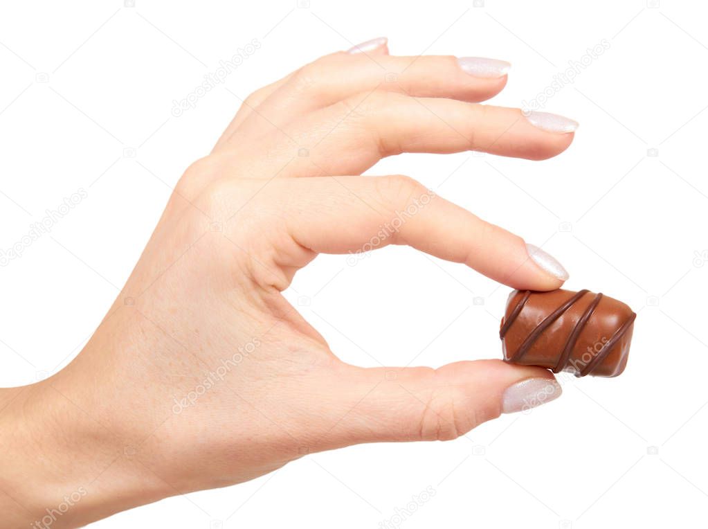 Hand with chocolate candy sweet dessert closeup. Isolated on white background