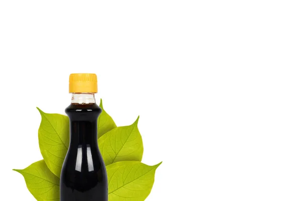 濃い醤油や葉の背景にバルサミコ ソースのボトル。白で隔離。アジア食品、日本有機調味料 — ストック写真