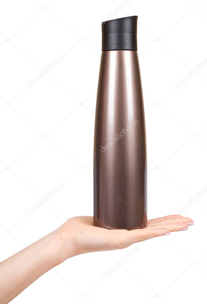 Hand with brown metal thermos, travel mug for hot drinks.
