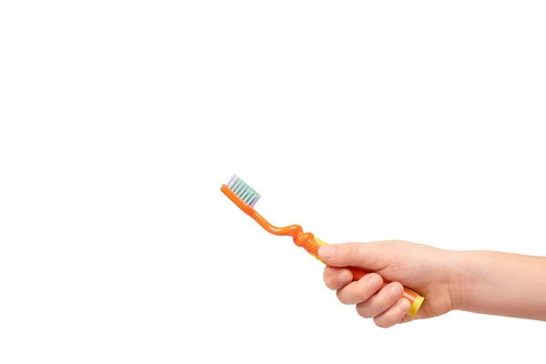 Kids hand with orange toothbrush, dental care concept — Stock Photo, Image