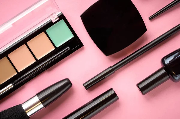Diferentes productos de maquillaje composición sobre fondo rosa — Foto de Stock
