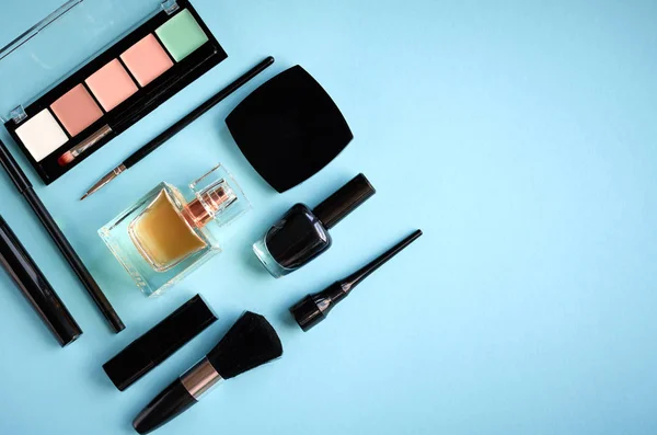 Diferentes productos de maquillaje composición sobre fondo azul — Foto de Stock