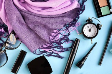 Mavi arka planda farklı makyaj ürünleri kompozisyonu