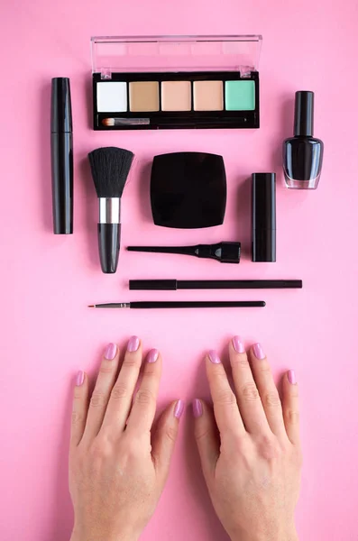Composición de diferentes productos de maquillaje con mano sobre fondo rosa — Foto de Stock