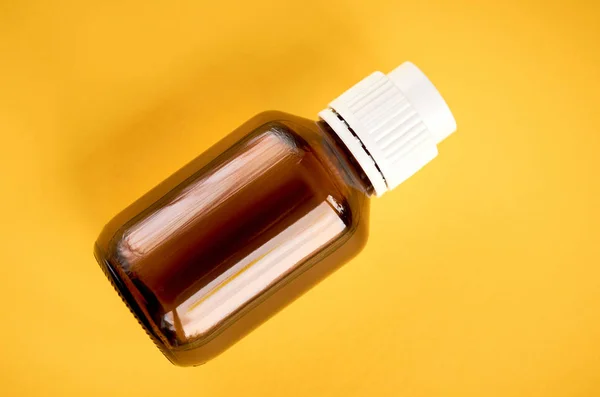 Xarope em composição garrafa de vidro no fundo amarelo — Fotografia de Stock