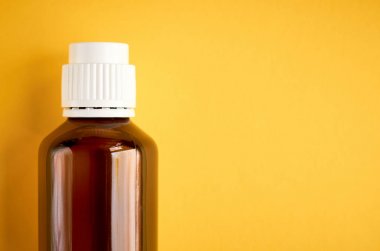 Sarı arka plan üzerinde cam şişe kompozisyon şurubu