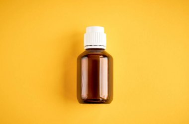 Sarı arka plan üzerinde cam şişe kompozisyon şurubu